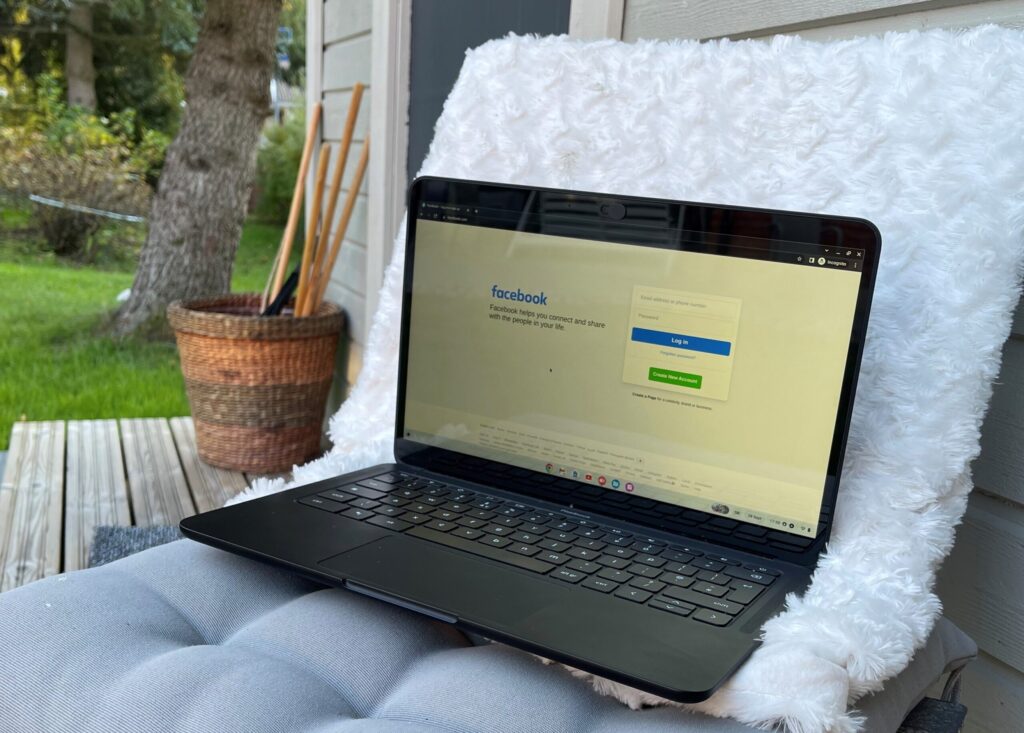 Laptop on a chair. The laptop has Facebook window open.